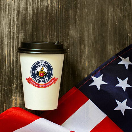 Closeup of American flag with coffee paper cup on a old wooden background. Mockup of coffee paper cup.